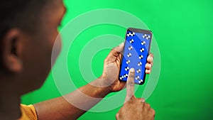 African American man scroll app online store in smartphone with tracking markers on green background