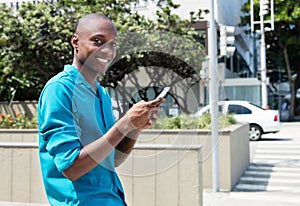 African american man sending message with mobile phone