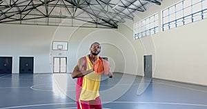 African American man shoots a basketball in an indoor court