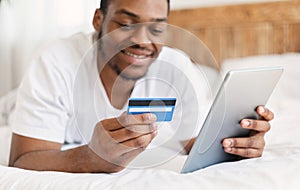 African American Man Shopping Online Using Digital Tablet At Home