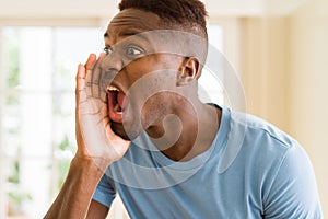 African american man shouting with rage, yelling excited with hand on mouth