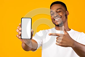 African American Man Showing Mobile Phone Screen, Yellow Background, Mockup photo