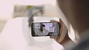 African American man with smartphone having video call with his female colleague