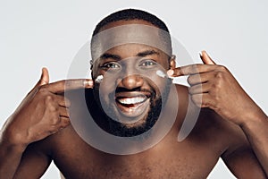African American man is smeared with face cream.