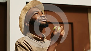 African american man smelling locally grown apples at supermarket photo