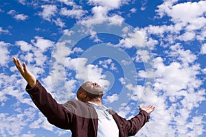 African American man stading outside with open arms.