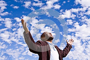 African American man stading outside with open arms. photo