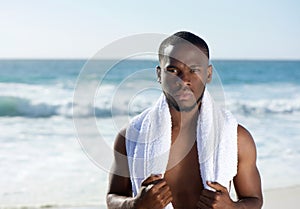 African american man standing at the beach with towel photo