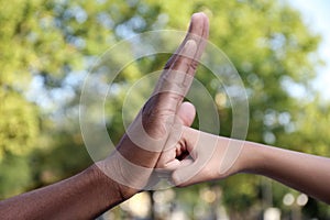 African American man stopping woman`s fist outdoors, closeup. Antiracism concept photo
