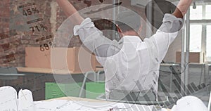 African-American man stretches in an office with graphs