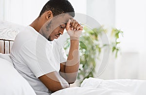 African American Man Suffering Depression Sitting In Bed At Home