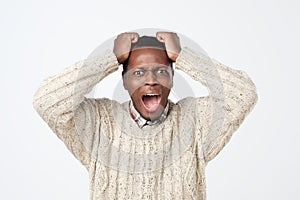 african american man in sweater in panic, shocked to hear bad news. Stressful situation concept