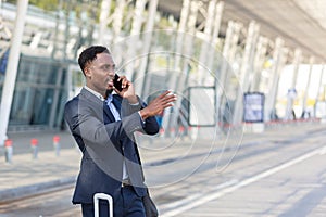 African American man talking on a cell phone near the airport, businessman arrived on a business trip