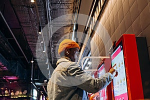 African-American man uses self-service kiosk to order snack