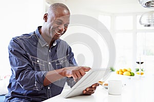 African American Man Using Digital Tablet At Home