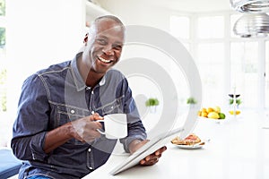 African American Man Using Digital Tablet At Home