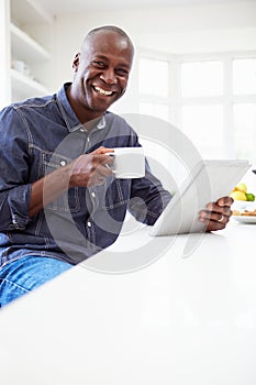 African American Man Using Digital Tablet At Home