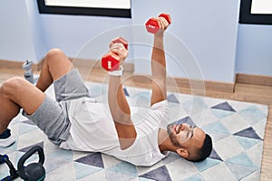 African american man using dumbbells training push up at home