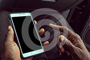 African American man using mobile smart phone with blank black screen. Mock up of a Black man holding device and touching screen.