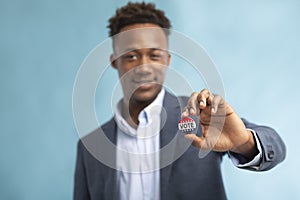 African american Man with Vote button on blue