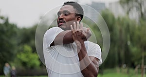 African american man warm up and strech in the park outdoors for a workout. Male prepared to running in the park