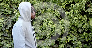 African american man wearing grey hooded sweatshirt top in garden, slow motion, copy space