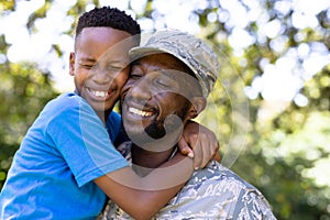 African American man wearing a military uniform holding his son