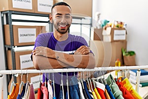 African american man wearing volunteer t shirt at donations stand happy face smiling with crossed arms looking at the camera