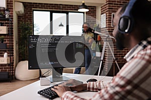 African american man with wireless headphones writing code on personal computer while girlfriend is using laptop