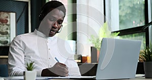 African American man working or studying in headset at office