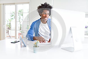 African American man working using computer with a happy face standing and smiling with a confident smile showing teeth