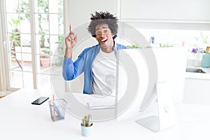 African American man working using computer pointing finger up with successful idea