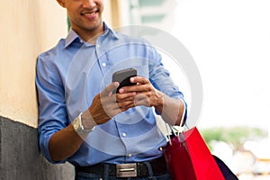 African American Man Writing Message On Phone Shopping Bags