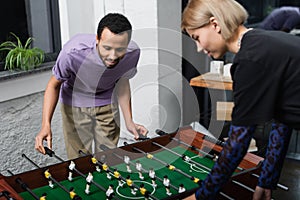 african american manager playing table football