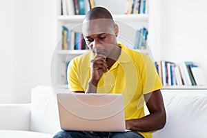 African american mature adult man in quarantine streaming video online at computer