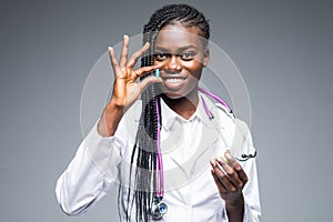 African American medical doctor holding pills, isolated on gray background
