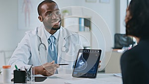 African American Medical Doctor Showing Mammography Test Results to a Patient on a Tablet Computer