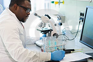 African-american medical doctor working in research lab. Science assistant making pharmaceutical experiments. Chemistry