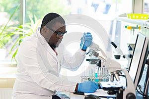 African-american medical doctor working in research lab. Science assistant making pharmaceutical experiments. Chemistry