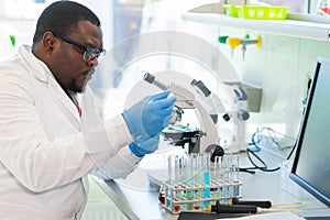 African-american medical doctor working in research lab. Science assistant making pharmaceutical experiments. Chemistry