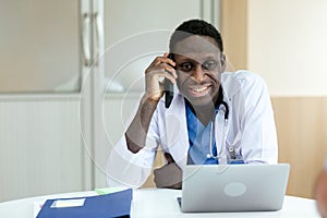 African American medical male doctor talking mobile phone and working.