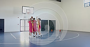 African American men celebrate a score in a basketball game at a gym