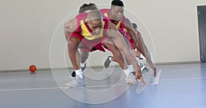 African American men play basketball indoors