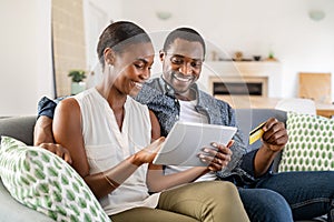 African american mid adult couple using credit card for online shopping