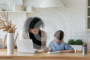 African American mom help Caucasian daughter with homework