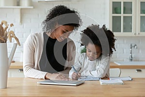 African American mom and little daughter study online