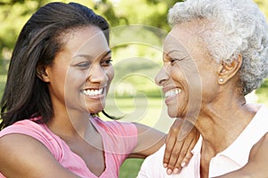 African American Mother And Adult Daughter Relaxing In Park