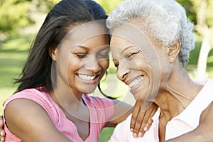 African American Mother And Adult Daughter Relaxing In Park