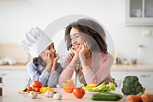 African american mother and daughter cooking tasty salad