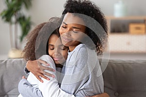 African American mother and daughter embracing, enjoying moment together